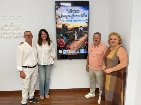 Cuatro personas posan junto al cartel de la Verbena de Granadillas 2026 durante su presentación